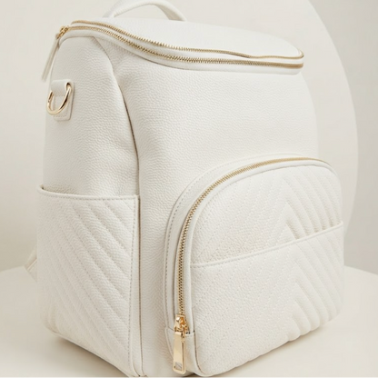 A white faux-leather backpack with gold-tone zippers and hardware, featuring a quilted front pocket, set against a clean white background.